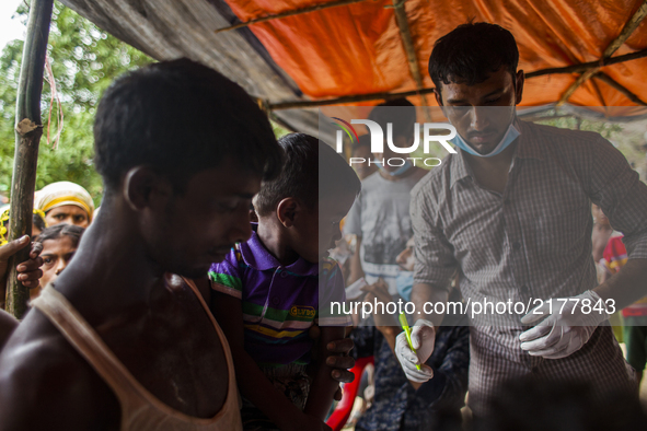 Rohingya Muslim refugees wait for medical support near a camp at a temporary makeshift shelters after crossing over from Myanmar into the Ba...