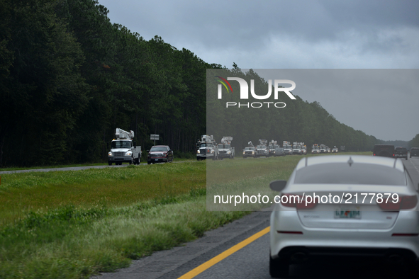 Utility vehicles drive along Interstate 75, near Jacksonville, FL, on September 11, 2017. Flood water resides from parts of Jacksonville, FL...