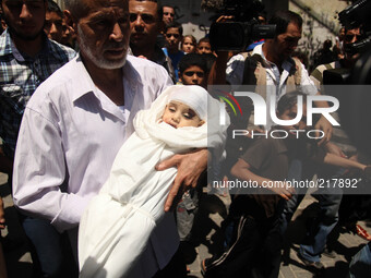 Palestinian mourners carry The body  child Ali Mohammed Deif ,, whose wife and child were killed in an air strike in Gaza late on August 19,...