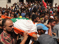 Palestinian mourners carry the bodies  of the wife of Mohammed Deif, Hamas's military leader, and his infant son Ali, whom medics said were...