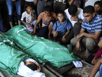 Relatives gather around the bodies of members from the alloh family in the mosque during their funeral in Deir al-Balah, central Gaza Strip,...