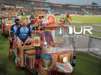 World-XI cricket team players waving the spectators while enjoying a ride on traditional tri-cycle rickshaw  at Gaddafi Cricket Stadium in L...