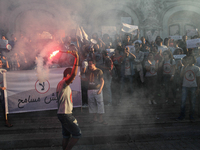 A protester holds a smoke grenade during a rally held by the movement 