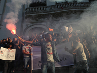 A protester shouts slogans as he holds a smoke grenade during a rally held by the movement 