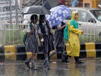 Pedestrians and commuters look on road in a sudden downpour time in the eastern Indian state Odisha's capital city Bhubaneswar on 13 Septemb...