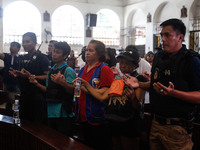 Surrounded by armed men and wearing protective vests, Eduardo Gabriel and Lina De Guzman, parents of slain teenager Reynaldo De Guzman, pray...