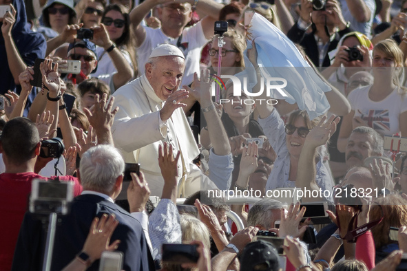 Pope Francis rides on the Popemobile through the crowd of the faithful as he arrives to celebrate his Weekly General Audience in St. Peter's...
