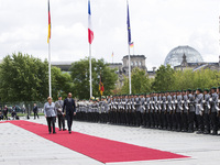 German Chancellor Angela Merkel and French Prime Minister Edouard Philippe review the guard of honour at the Chancellery in Berlin on Septem...