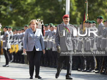 German Chancellor Angela Merkel congratulates a soldier of the guard of honour for his birthday before the arrival of French Prime Minister...