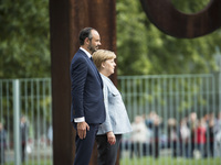 German Chancellor Angela Merkel and French Prime Minister Edouard Philippe listen to the national anthems at the Chancellery in Berlin on Se...