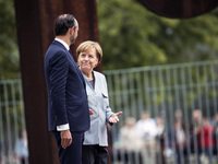 German Chancellor Angela Merkel and French Prime Minister Edouard Philippe are pictured after listening to the national anthems at the Chanc...
