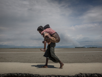 A Rohingya refugee is carrying his mother on his back at Shahpirer Dip, Teknaf, Bangladesh; September 14, 2017. Bangladesh will use troops t...