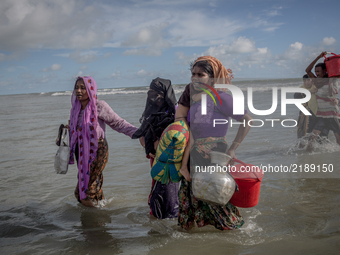 Rohingya refugee women walk to the shore of Bangladesh after crossing the Naf river by boat. Shahpirer Dip, Teknaf, Bangladesh; September 14...
