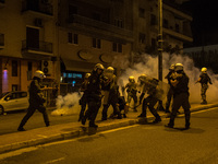 People run from tear gas fired by police after a group of protesters threw molotov cocktails during an anti-fascism demonstration in Athens...