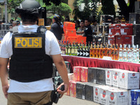  Indonesian police and customs officers examined the evidence of alcohol smuggling cases at regional police headquarters, Jakarta, Indonesia...