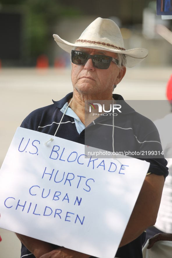 Man holds a sign saying 'U.S. blockade hurts Cuban children' during a rally to demand an end to the American blockade against Cuba (the Unit...