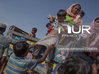 A Rohingya refugee kid is being pulled down from a truck that carried the refuges from the border to Balukhali refugee camps.  Cox’s Bazar,...