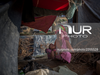 A Rohingya mother sits inside a temporary shelter with her child. Balikhali refugee camp, Cox’s Bazar, Bangladesh. September 16, 2017. (