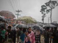 Rohingya refugees wait for relief under umbrella during rainfall at Balukhali Refugee Camp, Cox’s Bazar, Chittagong, Bangladesh. September 1...