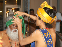 Tamil Hindu priest ties a turban on one of the festival sponsors during the Sapparam Festival at a Tamil Hindu temple in Ontario, Canada, on...