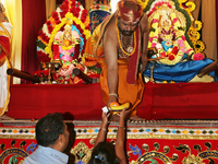 Tamil Hindu priest hands offerings to devotees during the Sapparam Festival at a Tamil Hindu temple in Ontario, Canada, on August 04, 2017....
