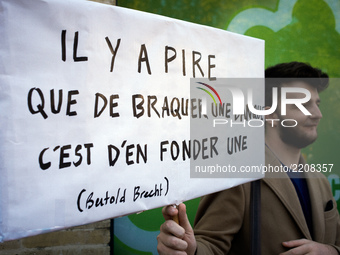 A protester hels a placard reading 'It's worse to open a bank than to rob one' (a citation of Bertold Brecht' during a demonstration in Toul...
