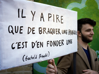 A protester hels a placard reading 'It's worse to open a bank than to rob one' (a citation of Bertold Brecht' during a demonstration in Toul...