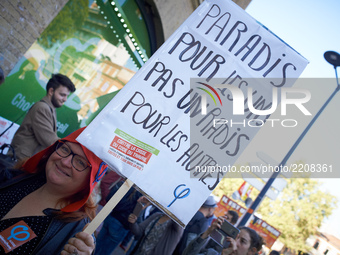 A demonstrator with a phrygian cap holds a placard reading 'Paradise for ones, nothing for others' during a protest in toulouse against the...