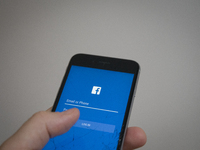 An iphone with a facebook login screen is seen with a striked out facebook logo in the background in this photo illustration on September 22...