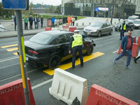 A man in an Alfa Romeo is seen being apprehended by police after failing to stop on time near a makeshift pedestrian crossing set up as part...