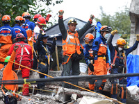 Japanese rescuers are seen during their rescue efforts in the rubble of the multi-family apartments on  Tlalpan Avenida due to the earthquak...
