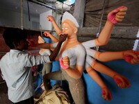 An Indian artist applying colours into the clay idol of goddess Durga at a puja mandap ahead of the Durga Puja festival in the eastern India...