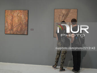 Visitors look at paintings by Ukrainian surrealist artist Ivan Marchuk at an exhibition in Ankara, Turkey on September 23, 2017. The exhibit...