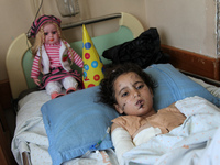 Lama Abu Hasira, 8 years, who lies on a bed at the Shifa hospital where she is undergoing treatment for shrapnel injury to her body. Heavy I...