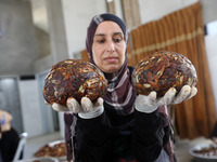 Palestinian women  work on the industry of presssed date in Dair Al Balah in the central Gaza Strip on  October 4, 2017. One of them supervi...
