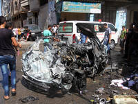 Palestinians around a destroyed car after an Israeli airstrike in Gaza City, on 25 August 2014. An israeli airstrike killed three palestinia...