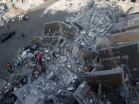 Palestinians inspect the rubble of the destroyed 15-storey Basha Tower after an Israeli airstrikes in Gaza City, on 26 August 2014. Tuesday'...