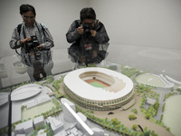 Photographers take a photo of the 1/150 scale model of the new national stadium for the 2020 Olympics during a press preview in Tokyo, Oct....