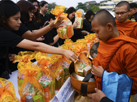 Thai Buddhist devotees give alms to a Buddhist monk in front of Bangkok's City Hall on October 13, 2017. King Bhumibol Adulyadej passed away...