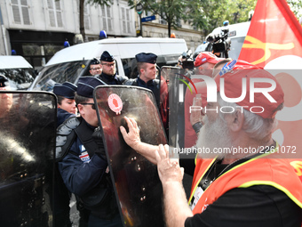 Metalworkers face off with police officers as they march with banners and flags in the streets of Paris on October 13, 2017. Several thousan...