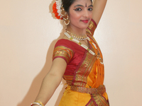 Bharatnatyam dancer practices an expressive dance backstage before a performance at a Tamil Hindu temple in Ontario, Canada. (