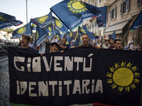 People hold a banner with a sign reading '
identity youth' as they wave flags during a march in downtown Rome, on October 14, 2017.
About...