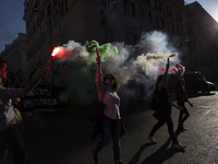People hold flares during a march in downtown Rome, on October 14, 2017.
About two thousand people took to the streets to defend the right...