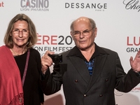 Jean François Stevenin (R) poses whith his wife in front of the photographers when they arrives at 9th Film Festival Lumiere In Lyon on Octo...