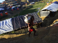 A Rohingya child carries drinking water at the Balukhali makeshift Camp in Cox's Bazar, Bangladesh, on October 7, 2017. According to the Uni...