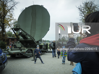 A child has his picture taken in front of a large radar dish on NATO day in Bydgoszcz, Poland on October 14, 2017. (