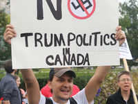 Protestor holds a sign saying 'No Trump Politics in Canada' during a rally against White Supremacy and Islamophobia at Queen's Park in Toron...