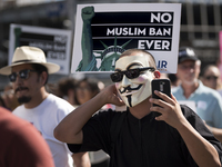 People take part in a protest against President Trump's travel ban, dubbed by activists as Muslim Ban 3.0, in Los Angeles, California on Oct...