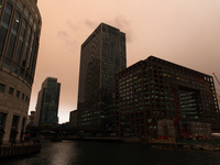 Darkened sky over London is pictured at financial district of Canary Wharf, London on October 16, 2017. The darkening is caused by warm air...