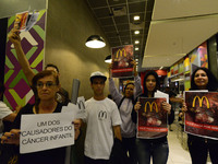 Protesters wave placards and leaflets during an animal rights march outsideand inside McDonald's restaurant on São Paulo on October 17, 2017...